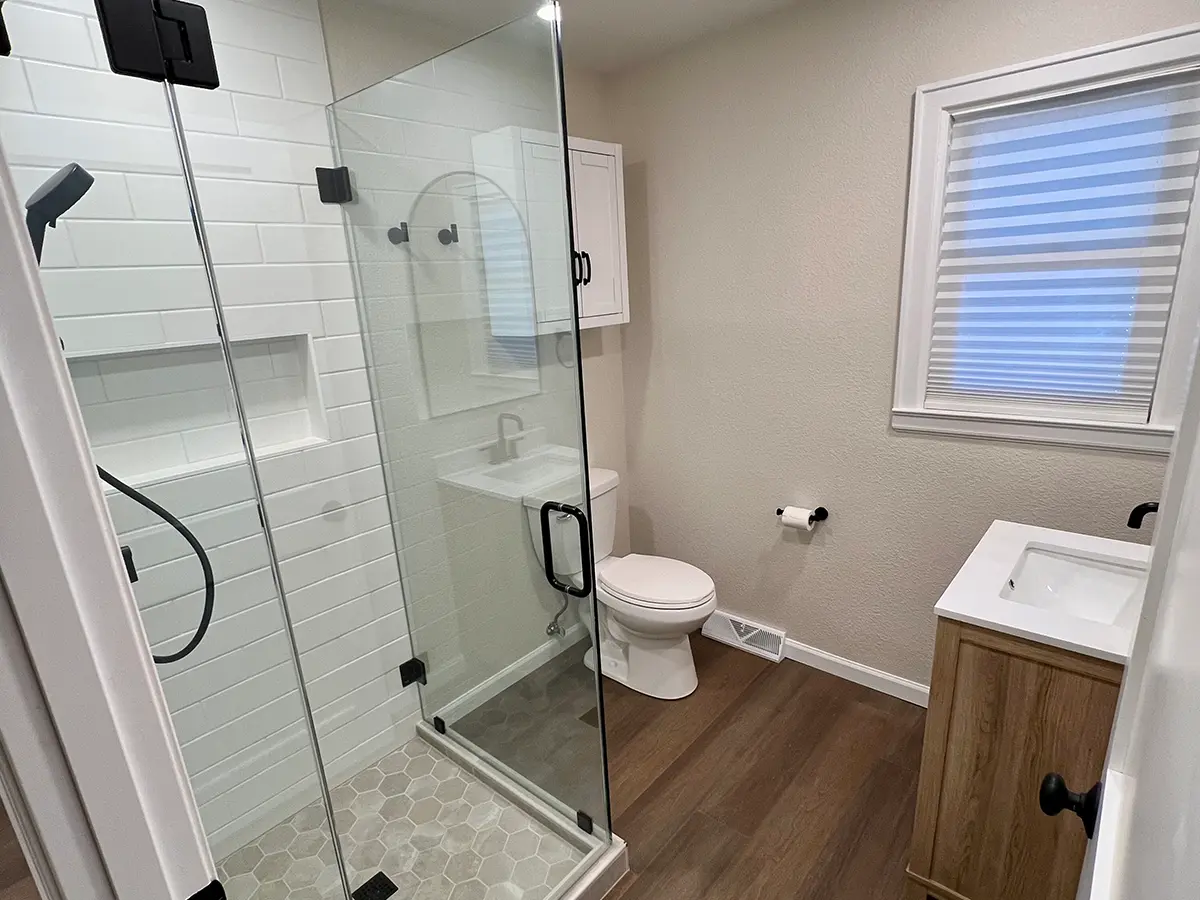 Luxury vinyl plank flooring in a small bathroom with a glass walk-in shower
