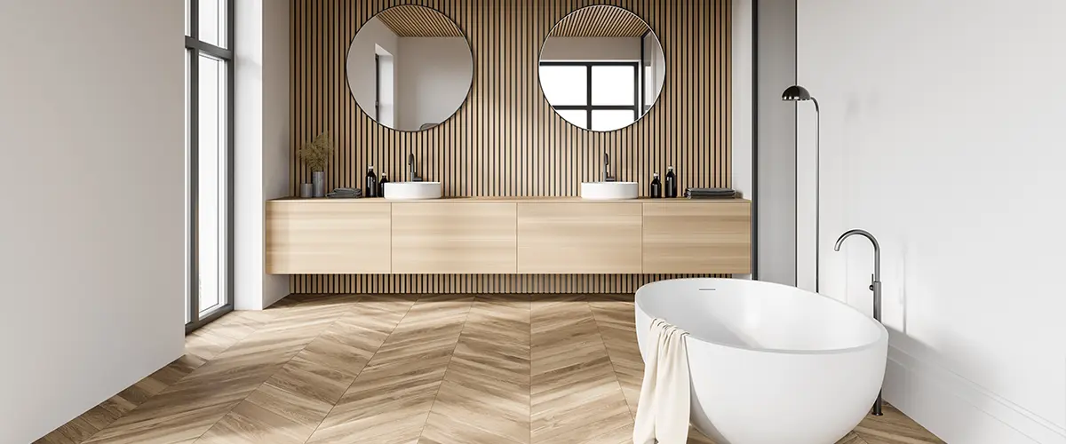 A wood floor in a bathroom with a freestanding tub