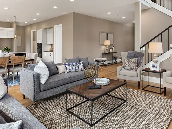 A living space with a gray couch, a wood table, and walls painted beige