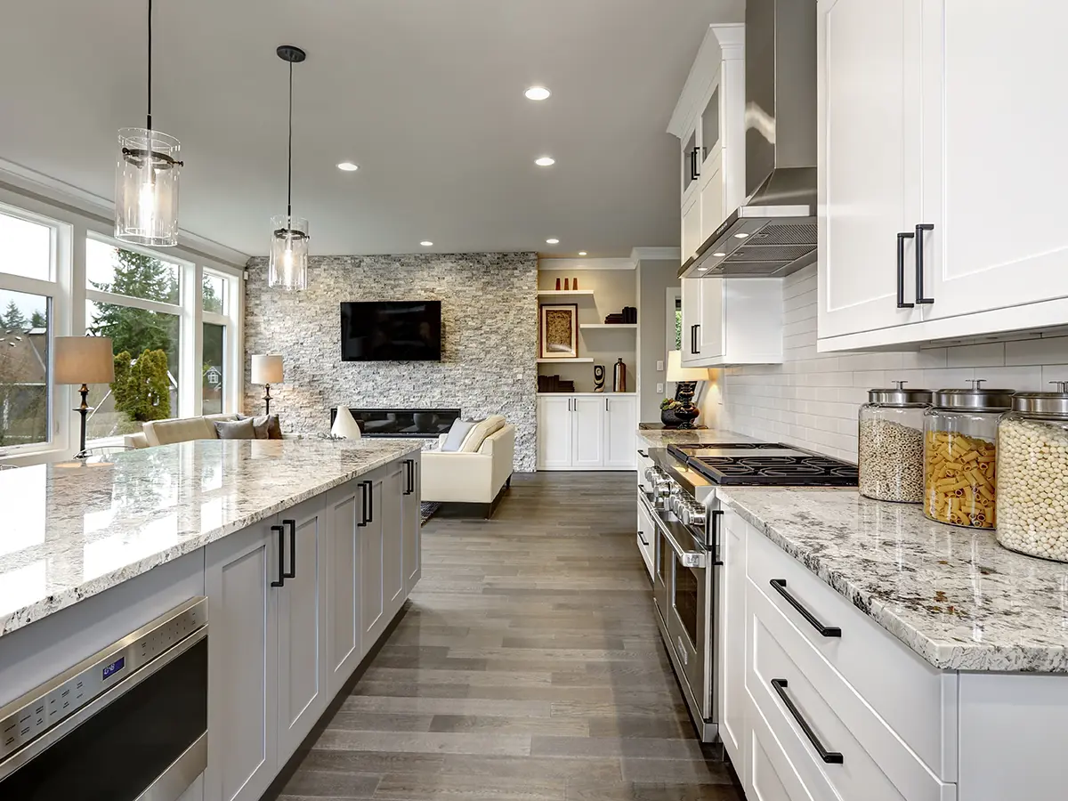 An open space kitchen with luxury vinyl plank flooring, pendant lights and white kitchen cabinets
