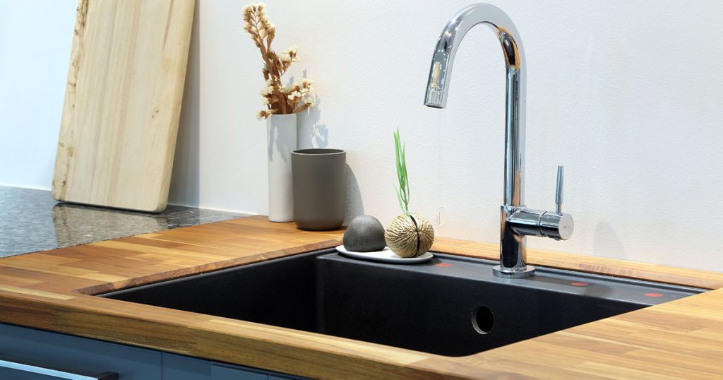 A kitchen sink with a cutting board