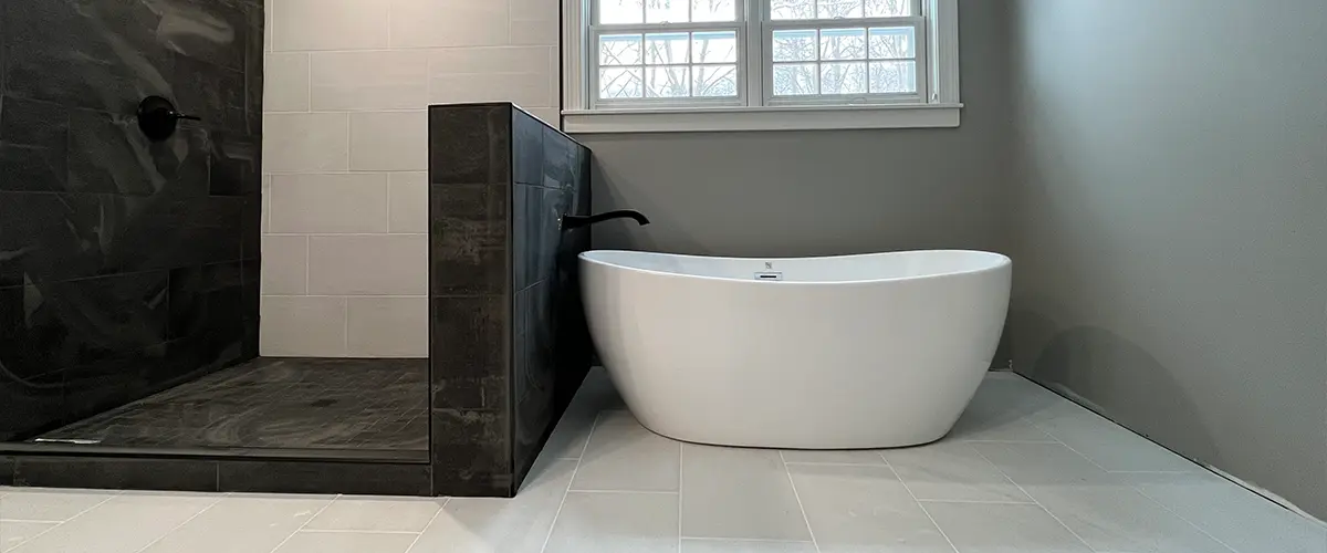 A freestanding tub with a black walk-in shower