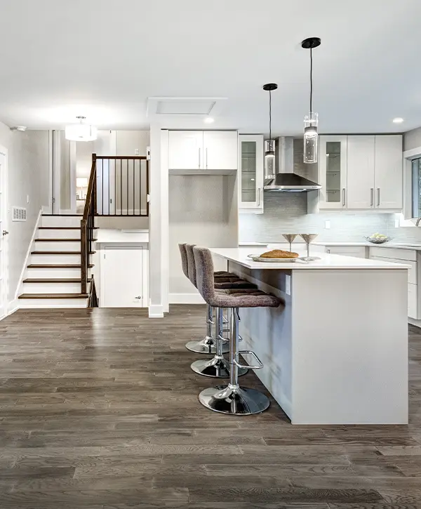 A basement with LVP flooring and a kitchen island