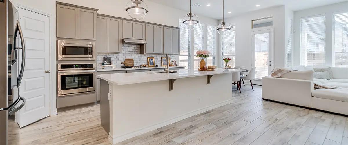 A kitchen with a large island and off-white cabinets