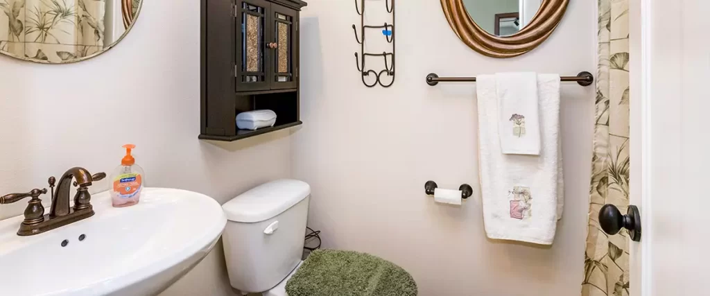 Small bathroom interior with a round pedestal sink and vintage faucet