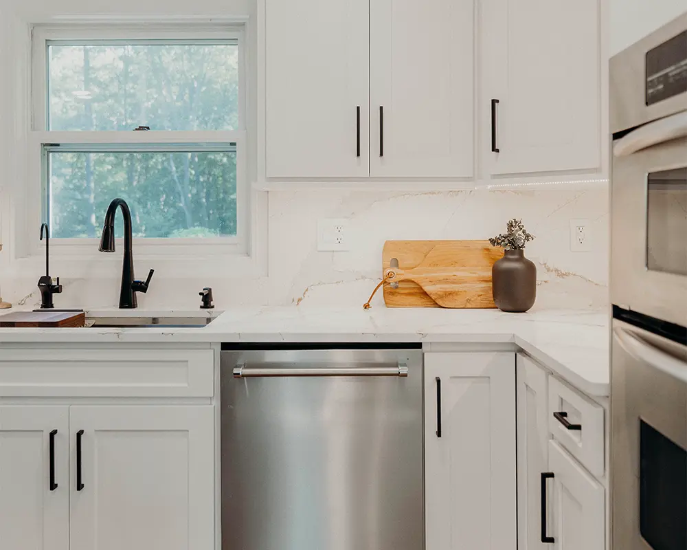 Quartz top and backsplash with white cabinets and black hardware