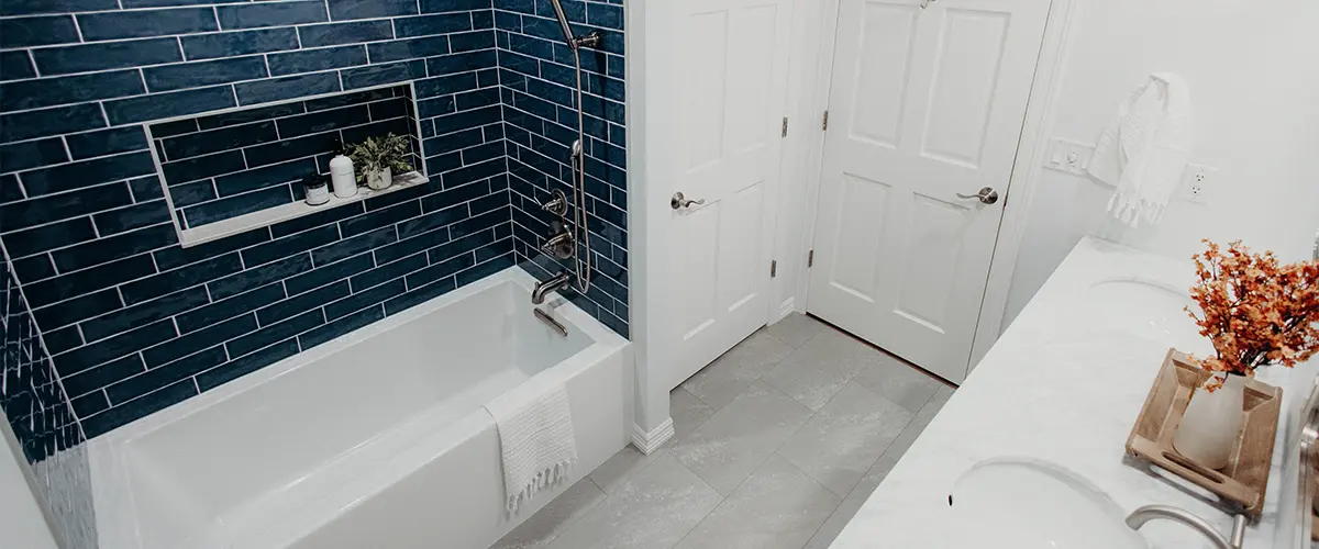 Modern bathroom with blue subway tiles and white fixtures, showcasing a clean and contemporary design.