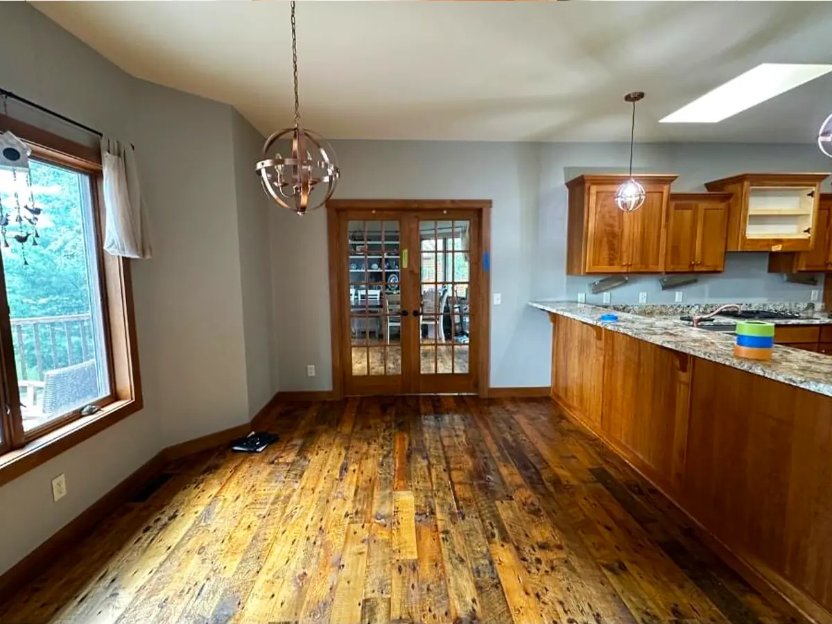 Dining area with wooden flooring and modern pendant light connected to kitchen