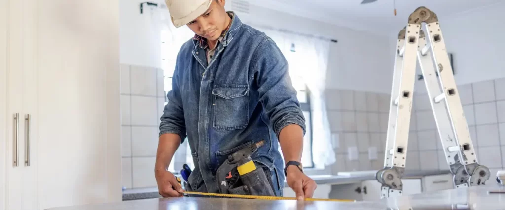 Contractor measuring a piece of material during home renovation