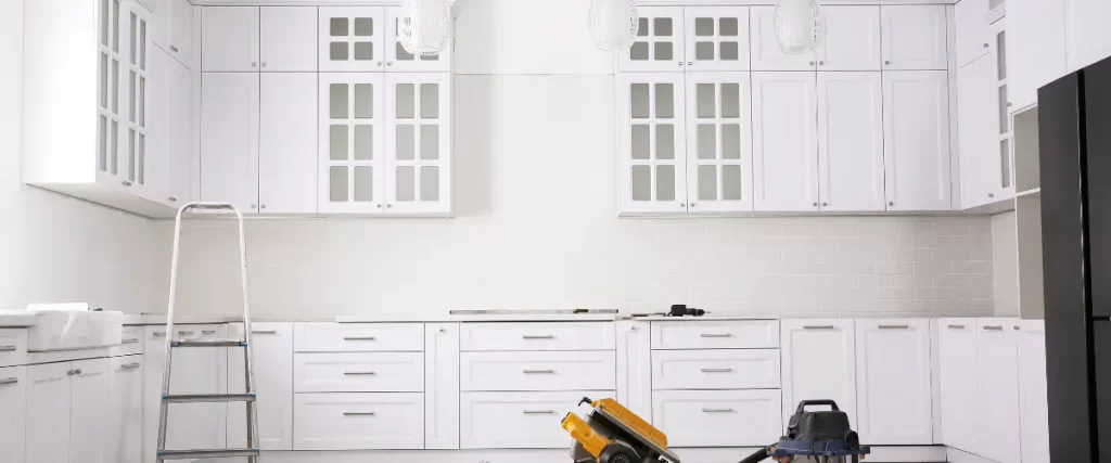 White kitchen cabinets with a power tool placed on the counter